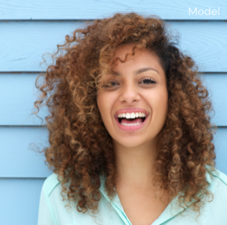 Model Smiling In Front of a Blue Wooden Wall